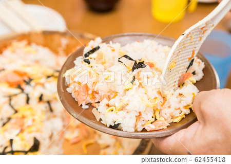 Senior eating chirashi sushi 62455418