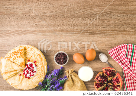 top view of traditional pancakes, jam, milk and square pattern napkin. delicious traditional dessert top view of traditional pancakes, jam, milk and square pattern napkin. delicious traditional dessert 62456341