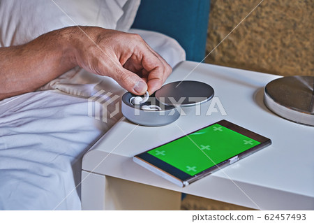 Man takes one of noise-masking sleepbuds from 62457493