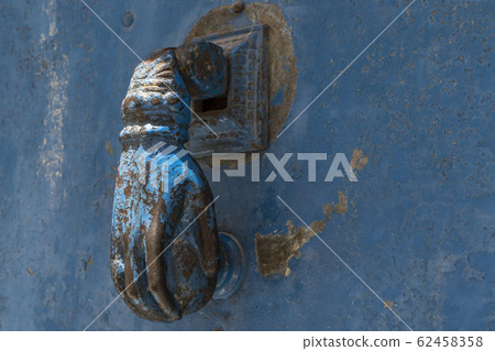 closeup hand shaped door knock on an old door closeup hand shaped door knock on an old door 62458358