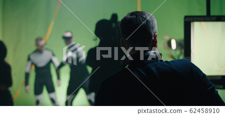 Director watching a shooting and discussing with an actor Director watching a shooting and discussing with an actor 62458910