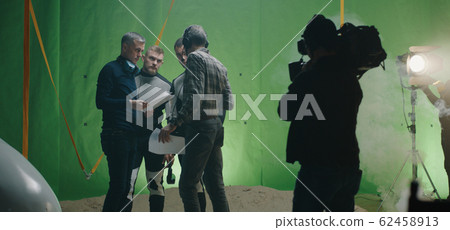 Director watching a shooting and discussing with an actor Director watching a shooting and discussing with an actor 62458913