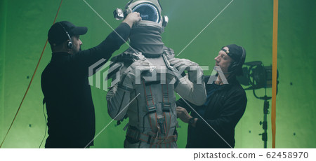 Crew members dressing an actor Crew members dressing an actor 62458970
