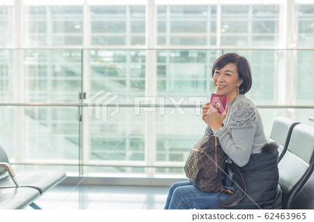 Emotional scene of a middle woman who makes a ticket reservation procedure with a smartphone 62463965