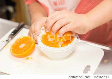 Children's hand making fresh juice Children's hand making fresh juice 62465415