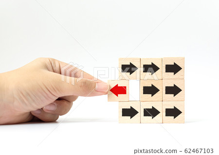 Hand choose wooden block with red arrow facing the opposite direction black arrows Hand choose wooden block with red arrow facing the opposite direction black arrows 62467103