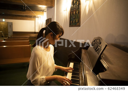 A woman playing the piano 62468349