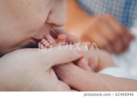 Child's hand, fingers close-up.mom kisses a newborn, the concept of massage childhood, health, ecology, hygiene, IVF Child's hand, fingers close-up.mom kisses a newborn, the concept of massage childhood, health, ecology, hygiene, IVF 62468946
