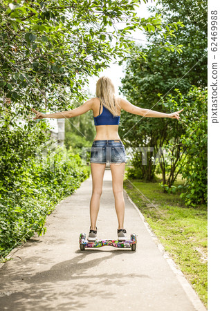 Young beautiful girl with long legs rides a gyro Young beautiful girl with long legs rides a gyro 62469988