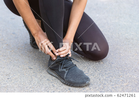 Close up Athlete running woman use hands hold on his ankle while running in the morning.Ankle injury on woman after traning for warm up her muscle. Close up Athlete running woman use hands hold on his ankle while running in the morning.Ankle injury on woman after traning for warm up her muscle. 62471261