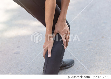 Close up Athlete running woman use hands hold on his ankle while running in the morning.Ankle injury on woman after traning for warm up her muscle. Close up Athlete running woman use hands hold on his ankle while running in the morning.Ankle injury on woman after traning for warm up her muscle. 62471262