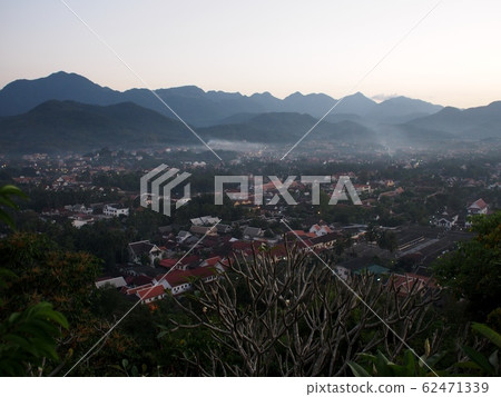 evening landscape scene view from PHU SI temple over LUANG PRABANG province in LAOS, a cute lovely UNESCO cultural heritage place town ex-capital city with green mountain surround  62471339