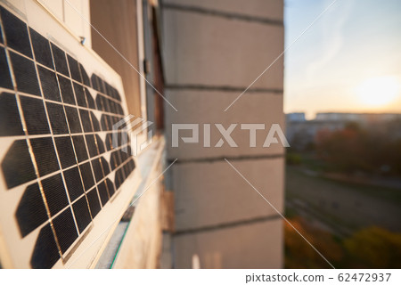 Solar panel on the window of a high-rise residential building, urban blurred background Solar panel on the window of a high-rise residential building, urban blurred background 62472937