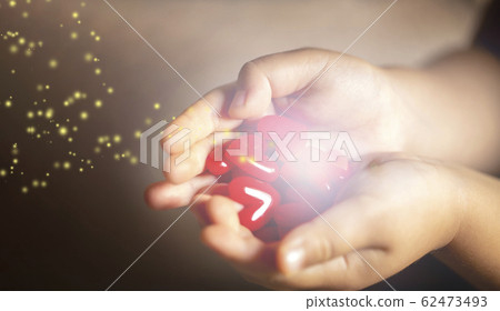 Child's hand with lots of red heart motifs shining Child's hand with lots of red heart motifs shining 62473493