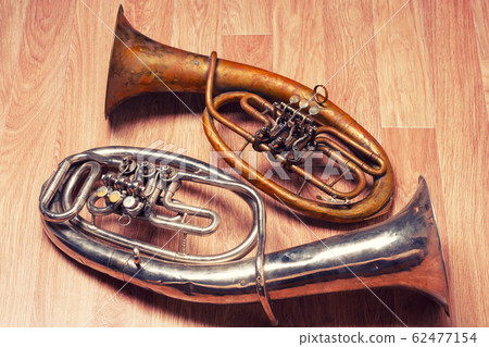 two old rusty alto saxhorn on wooden background 62477154