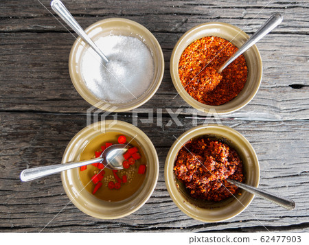 food flavoring concept. sugar , cayenne pepper, vinegar and chili paste in small bowl for food flavoring on wooden table background 62477903