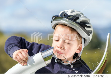 Boy drinking water from street bubbler Boy drinking water from street bubbler 62478300