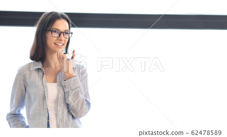 Girl standing and using mobile voice recognition function 62478589