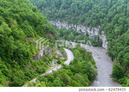 Mountain gorge with a river below. 62479435