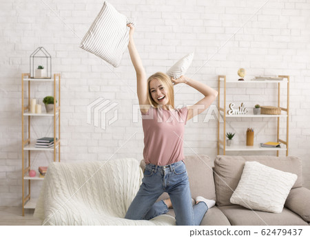 Happy young woman having fun alone at home 62479437