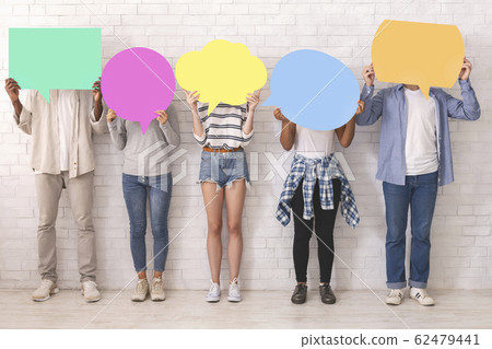Teenagers in casual clothes hiding behind colorful communication bubbles 62479441