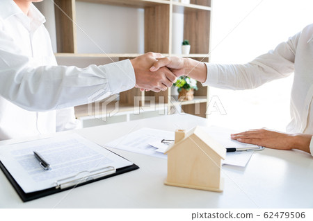 House developers and customer shaking hand after 62479506
