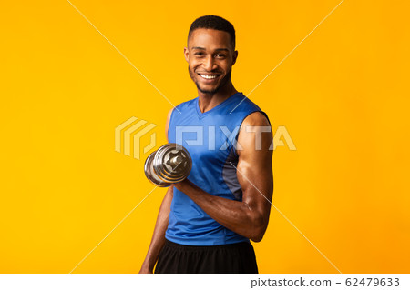 African bodybuilder pumping up dumbbells at orange studio African bodybuilder pumping up dumbbells at orange studio 62479633