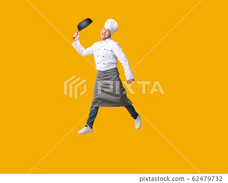 Chef Jumping Holding Frying Pan Having Fun Posing In Studio 62479732