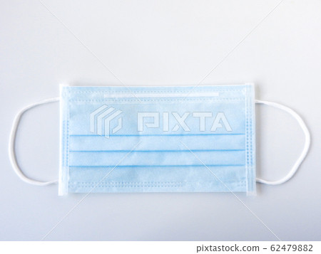 Top view of a blue disposable surgical mask isolated on white background. Not used.  Mask used for prevent the spread of the disease. Novel coronavirus (COVID-19). Health  and medical concept. 62479882