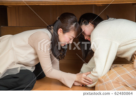 Parent and child hiding under the table due to earthquake Parent and child hiding under the table due to earthquake 62480864