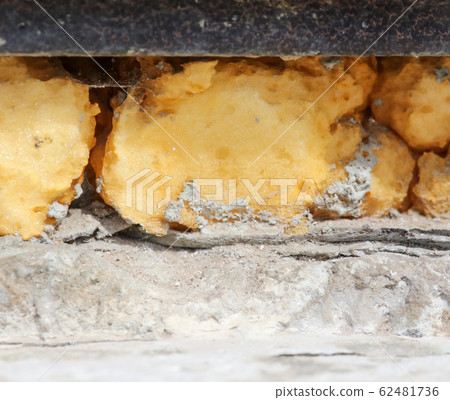 Construction foam in the wall slit as a background Construction foam in the wall slit as a background 62481736