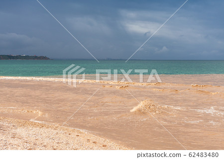 Muddy river water mixes with blue seawater. Black 62483480