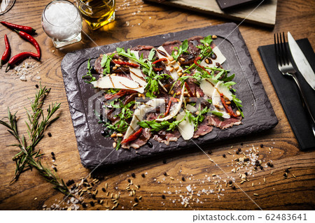 Beef carpaccio served on a board in restaurant Beef carpaccio served on a board in restaurant 62483641