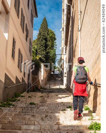 Woman rising up on stony staircase in old town Woman rising up on stony staircase in old town 62484049