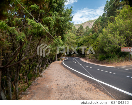 Beautiful image of curved road going to high mountain through laurel forest on Tenerife island, Canaries 62484223