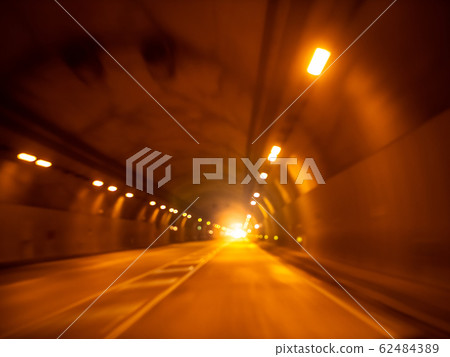 Blurred image of car riding in dark tunnel through mountain 62484389