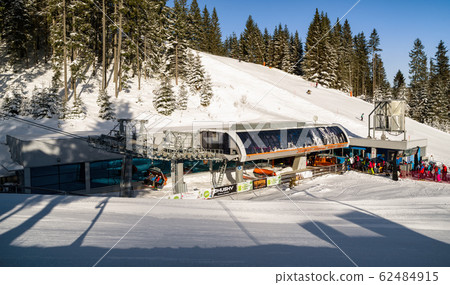 DEMANOVSKA DOLINA, SLOVAKIA - FEBRUARY 8: Ski-lift chair and skiers in ski resort Jasna in Low Tatras mountains on February 8, 2020 in Demanovska Dolina DEMANOVSKA DOLINA, SLOVAKIA - FEBRUARY 8: Ski-lift chair and skiers in ski resort Jasna in Low Tatras mountains on February 8, 2020 in Demanovska Dolina 62484915