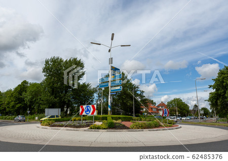 Cars entering a roundabout with traffic direction 62485376