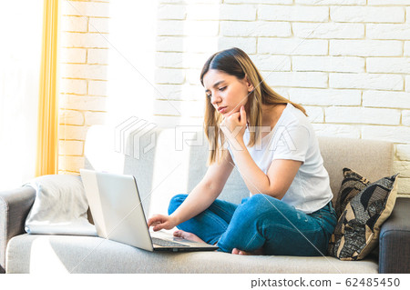 young attractive woman at home tiredly seeking for a job or rent in internet young attractive woman at home tiredly seeking for a job or rent in internet 62485450