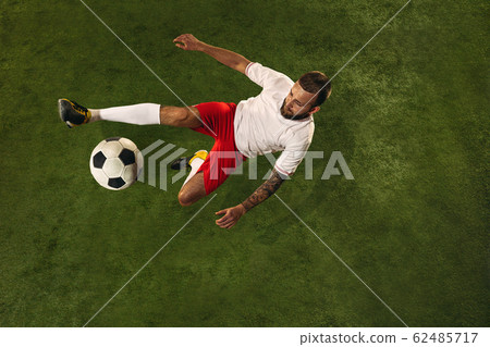 Top view of caucasian football or soccer player on green background of grass 62485717
