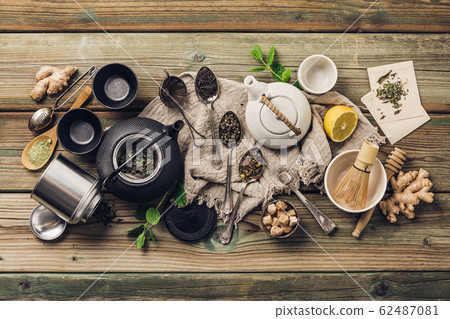 Various tea and teapots composition, dried herbal, green, black tea and matcha tea on wooden table background Various tea and teapots composition, dried herbal, green, black tea and matcha tea on wooden table background 62487081