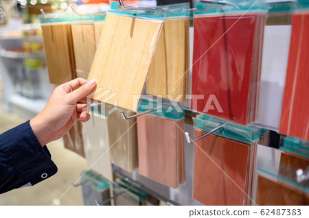Male hand choosing wood panel material 62487383