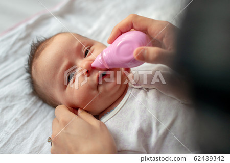 mother using baby nasal aspirator mucus nose suction mother using baby nasal aspirator mucus nose suction 62489342
