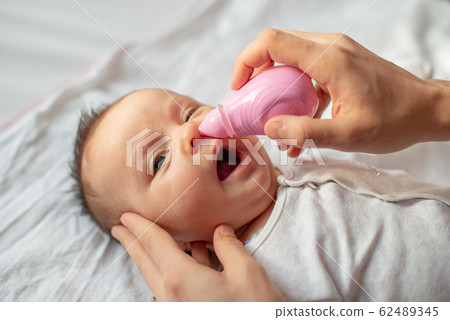 mother using baby nasal aspirator mucus nose suction mother using baby nasal aspirator mucus nose suction 62489345