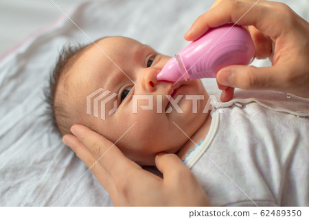 mother using baby nasal aspirator mucus nose suction 62489350