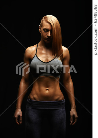 Young fit women in sports equipment, sports embossed female body, black background, hard light. Copy space, sports banner 62489368