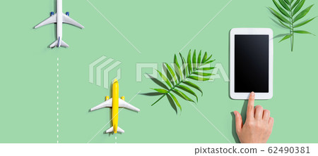Person using a tablet computer with small airplanes Person using a tablet computer with small airplanes 62490381