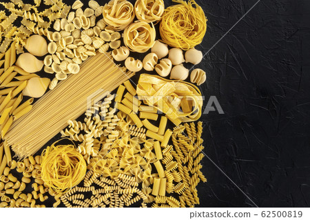 Italian pasta design template with copy space, a flat lay of many different pasta types, shot from above on a black background with a place for text 62500819
