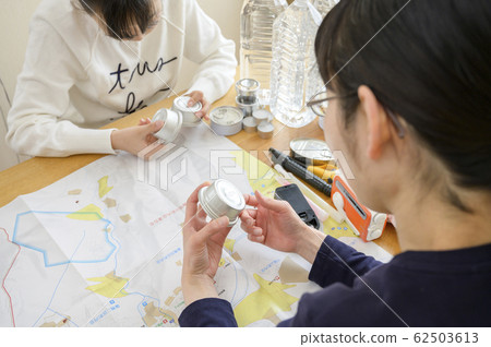 Family members checking emergency supplies (checking the expiration date) 62503613