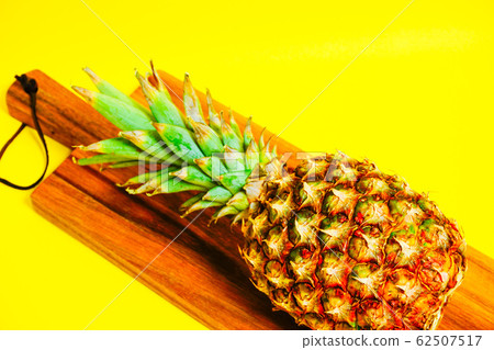 Ripe pineapple on a cutting board Ripe pineapple on a cutting board 62507517